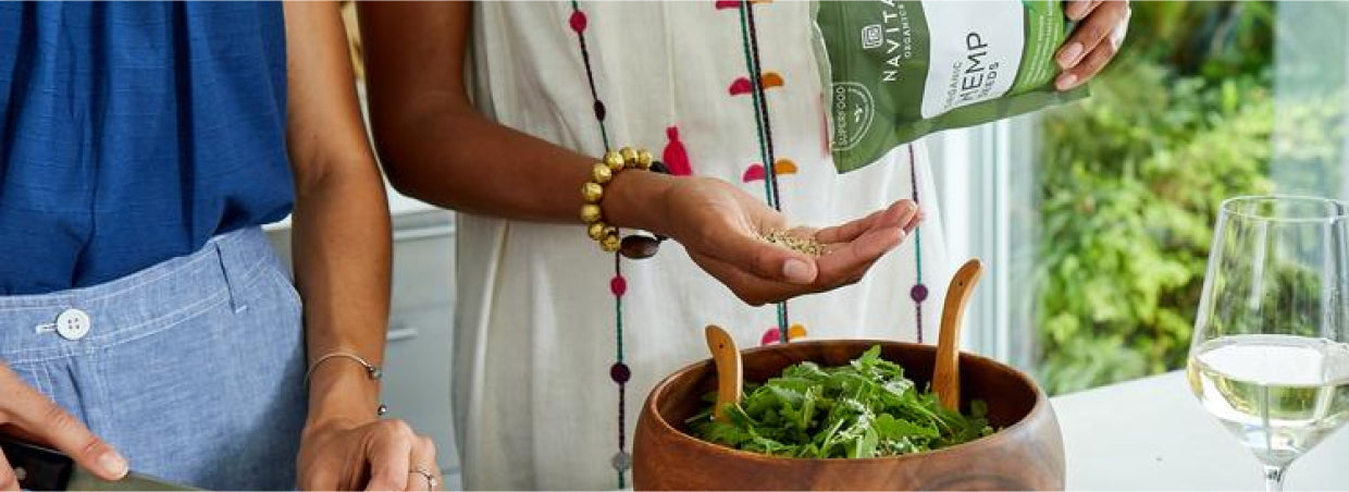 A couple using Navitas Organics hemp seeds for their salad