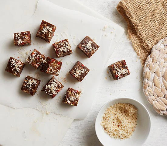 Superfood energy bites made with Navitas Organics Adaptogan Blend and sprinkled with shredded coconut