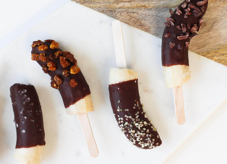 Banana popsicles dipped in chocolate and sprinkled with superfoods