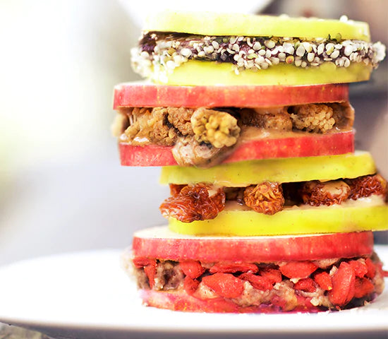 Stacked apple slice sandwiches packed with goji berries, goldenberries, mulberries and hemp seeds