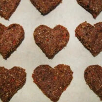 Heart-shaped paleo & vegan cookies made with goji berries, hemp seeds and cacao powder