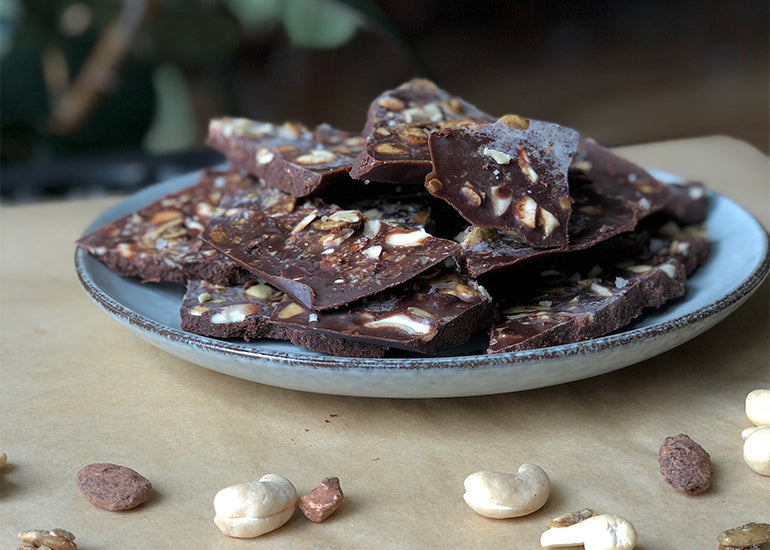 A plate of dark chocolate pieces made with Navitas Organics Cacao Powder, Cacao Butter, Cashew Nuts and other mixed nuts