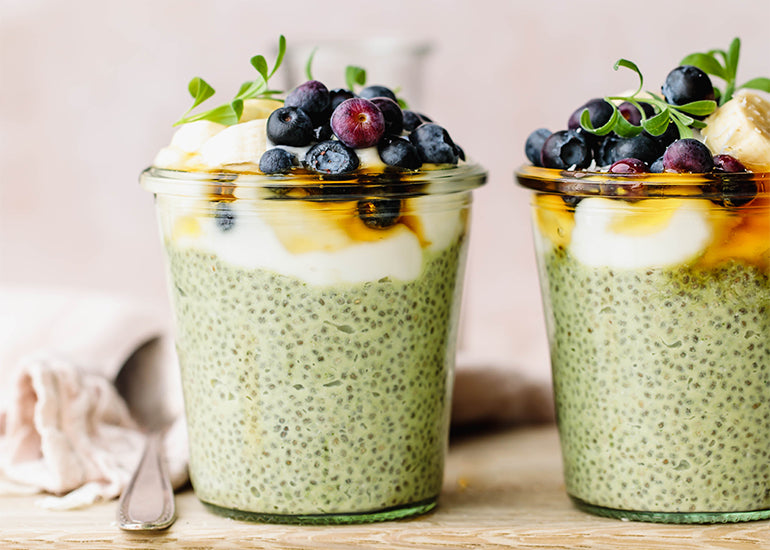 Chia pudding cups made with Navitas Organics Matcha Powder and Chia Seeds, topped with fresh blueberries and banana slices, drizzled with honey