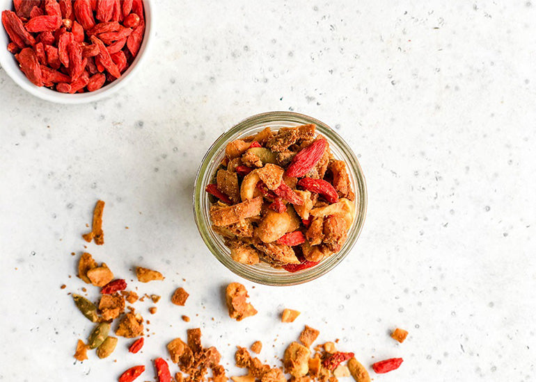 Granola made with various seeds and nuts and Navitas Organics Goji Berries in a glass mason jar