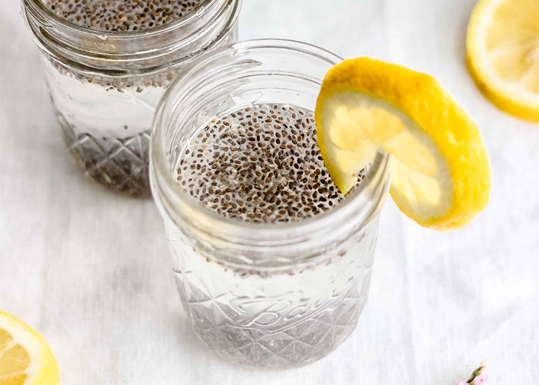 A glass of chia water made with Navitas Organics Chia Seeds, garnished with a lemon wedge