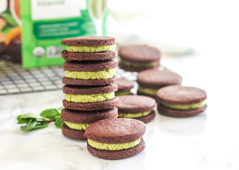 Matcha mint chocolate sandwich cookies made with Navitas Organics Matcha Powder and Cacao Powder in a stack on a counter