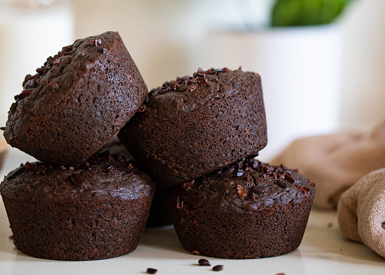 A stack of double chocolate muffins made with Navitas Organics Cacao Powder, Cacao Nibs and Cacao Sweet Nibs