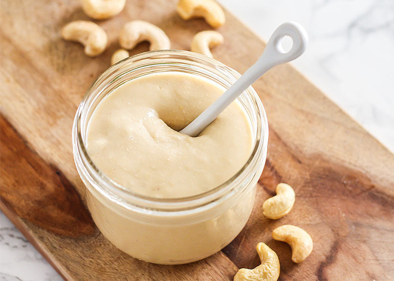 A mason jar filled with cashew butter made with Navitas Organics Cashew Nuts and Maca Powder
