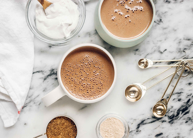 Mugs filled with hot cocoa made with Navitas Organics Cacao Powder and Maca Powder