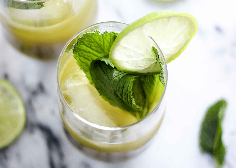 A refreshing ginger mint matcha cocktail made with Navitas Organics Matcha Powder, garnished with fresh mint leaves and lime