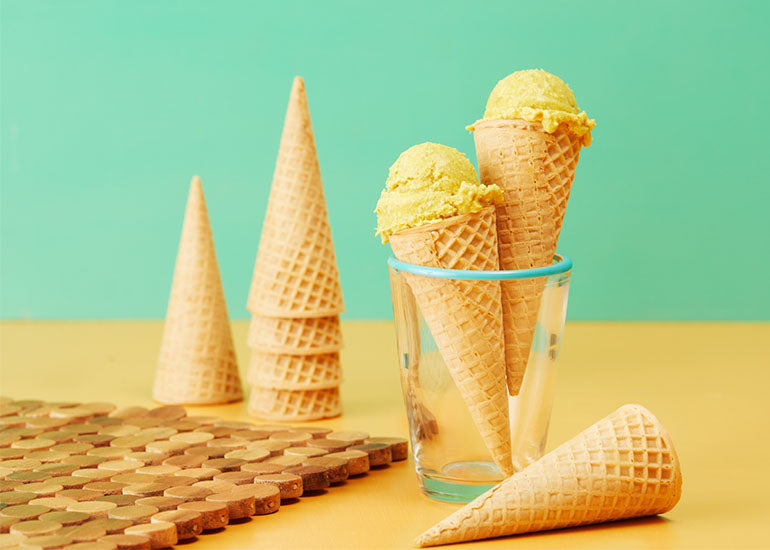 Scoops of golden milk ice cream made with Navitas Organics Turmeric Powder in ice cream cones