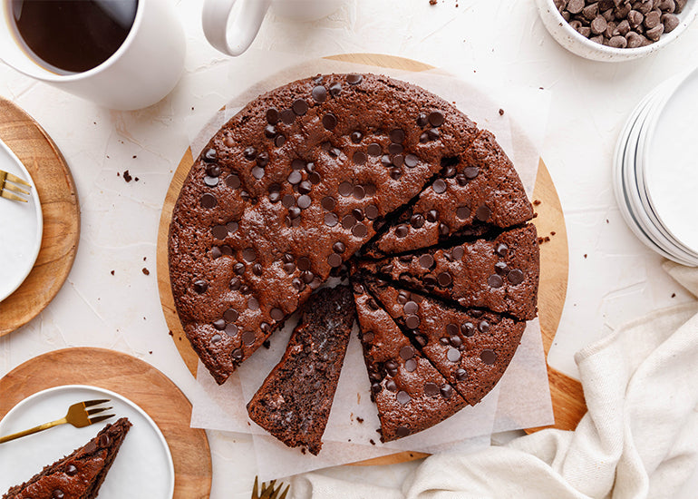 A coffee brownie torte made with Navitas Organics Grain-Free Flour and Cacao Powder, sliced and served with coffee