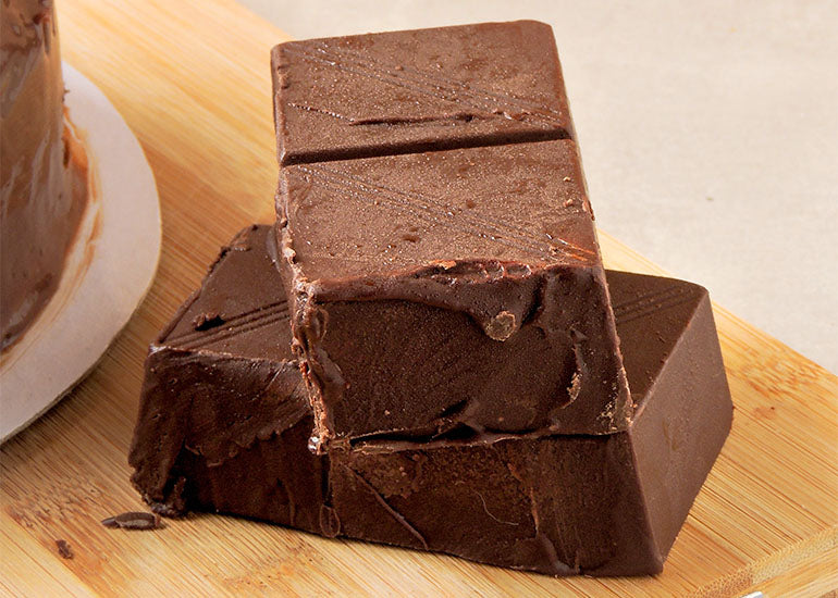 Small blocks of fudge made with Navitas Organics Acai Powder and Cacao Butter.