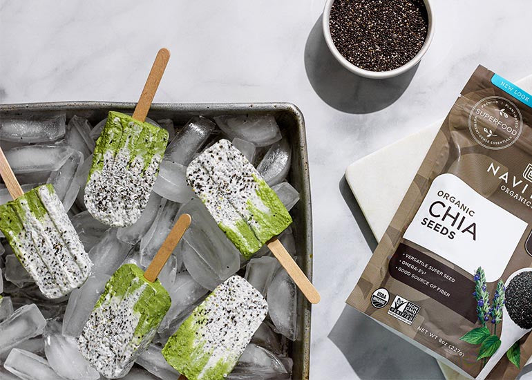 A pan filled with ice and topped with popsicles made with Navitas Organics Vanilla & Greens Essential Blend, Matcha Powder and Chia Seeds.