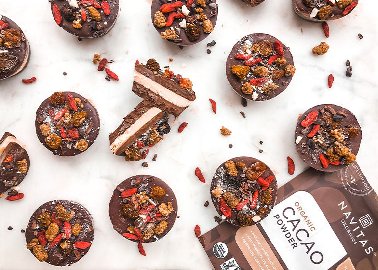 A spread of cacao butter cups made with Navitas Organics Cacao Powder and Cacao Butter, topped with Navitas Organics Goji Berries, Mulberries, Goldenberries, and Cacao Nibs.