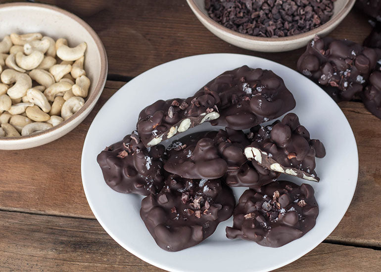 A plate of cacao cashew clusters made with Navitas Organics Cashew Nuts and Cacao Nibs.