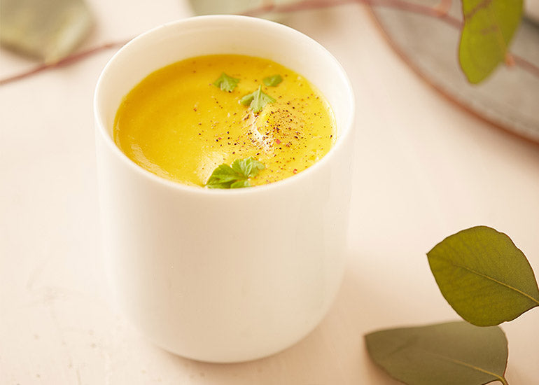 A cup filled with a creamy soup made with Navitas Organics Cashew Nuts and Goji Berries.