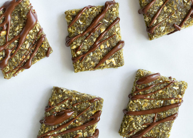 Rows of chewy hemp bars with a chocolate drizzle, made with Navitas Organics Hemp Powder and Cacao Powder.