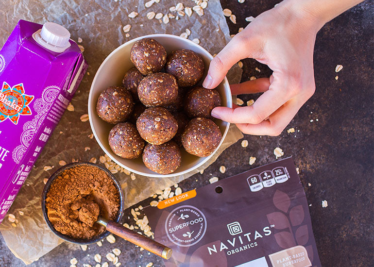 A bowl of chocolate chai energy bites made with Navitas Organics Vanilla & Greens Essential Blend Protein Powder, Chia Seeds and Cacao Powder