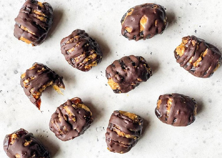 Butterfinger stuffed dates made with Navitas Organics Chia Seeds and Mulberries, drizzled with chocolate made with Navitas Organics Cacao Powder.