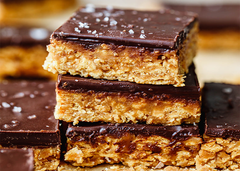 A stack of gluten-free peanut butter cornflake bars made with Navitas Organics Cacao Butter.