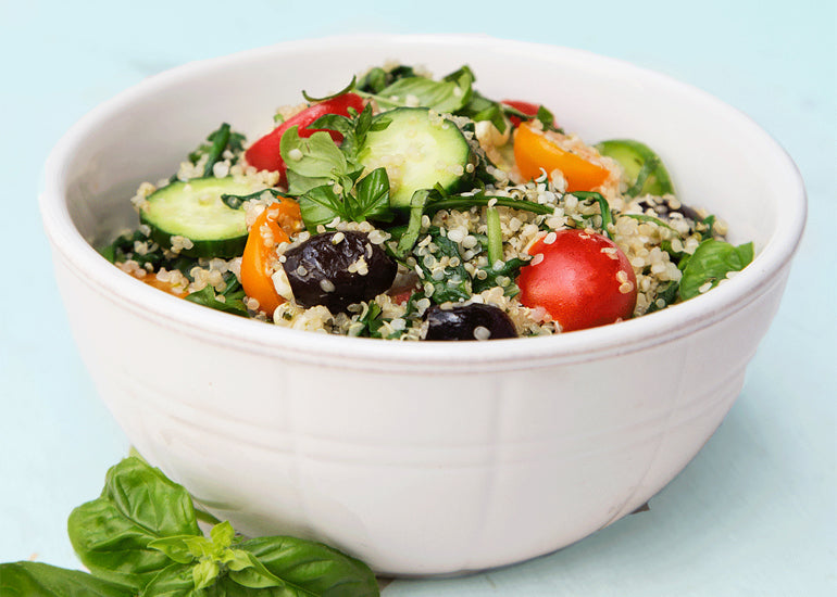 A bowl filled with quinoa and fresh vegetables, sprinkled with Navitas Organics Hemp Seeds.