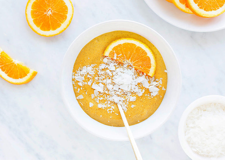 An orange smoothie bowl made with Navitas Organics Superfood+ Immunity Blend and Chia Seeds.