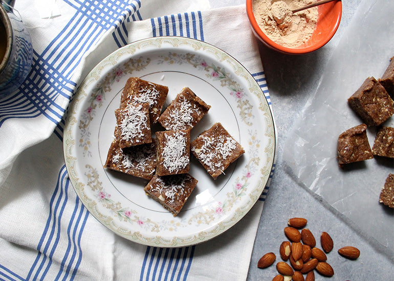 A plate of nutty chocolate squares made with Navitas Organics Maca Powder and Cacao Nibs.