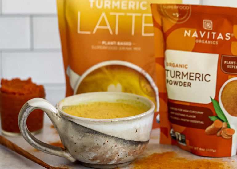 A pumpkin spice golden milk latte made with Navitas Organics Turmeric Powder in a ceramic mug.