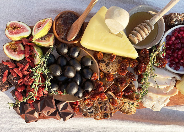 A charcuterie board made with various Navitas Organics Dried Fruit and Cashew Nuts, Power Snacks, and fresh fruit and other organic ingredients.