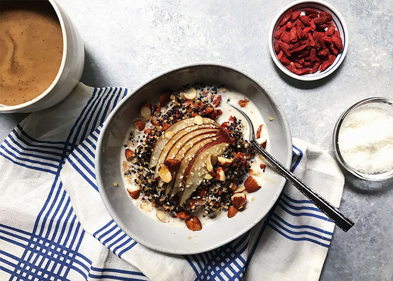 A bowl of multigrain hot cereal mixed with Navitas Organics Goji Berries, topped with sliced pears and Navitas Organics Chia Seeds.