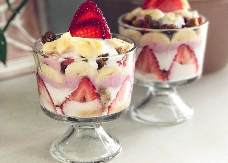 Two glass dishes filled with layered fruit and yogurt parfaits, made with Navitas Organics Mulberries, Goji Berries and Chia Seeds.