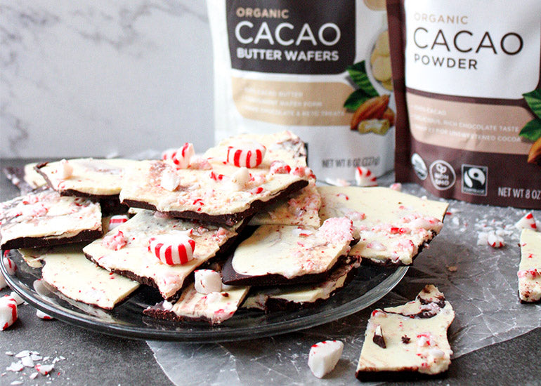 A plate of dark chocolate peppermint bark made with Navitas Organics Cacao Powder, Cacao Wafers and Cacao Butter Wafers, topped with crushed peppermint candies.