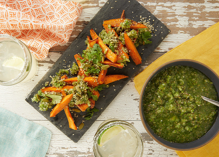 A platter of sweet potato fries served with salsa verde made with Navitas Organics Wheatgrass Powder and Chia Seeds.