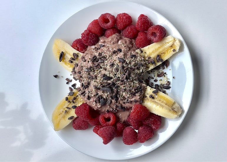 A chocolate raspberry banana split made with Navitas Organics Cacao Powder, Cacao Nibs and Hemp Seeds