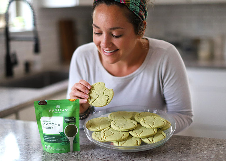 Mommy blogger Eryka Spera of Busy Little Izzy holding a plate of matcha sourdough sugar cookies made with Navitas Organics Matcha Green Tea Powder.