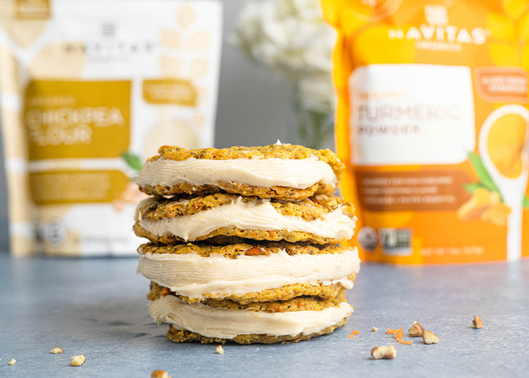 A stack of carrot cake cookie sandwiches made with Navitas Organics Chickpea Flour, Turmeric Powder and Chia Seeds on a counter