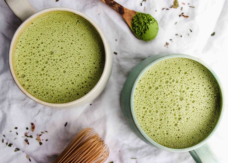 Two mugs of steamy green beauty elixir lattes