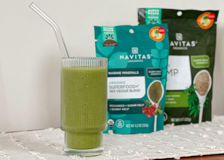 A tall glass filled with a green smoothie made with Navitas Organics Hemp Seeds and Superfood+ Sea Veggie Blend