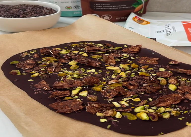 Mint chocolate bark made with Navitas Organics Semi-sweet Cacao Wafers and Bittersweet Cacao Wafers, topped with grain-free granola, pistachios and Navitas Organics Cacao Sweet Nibs.