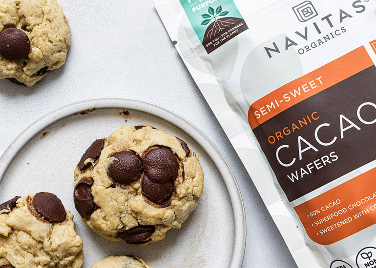 A plate of soft-baked chocolate chip cookies made with Navitas Organics Semi-sweet Cacao Wafers.