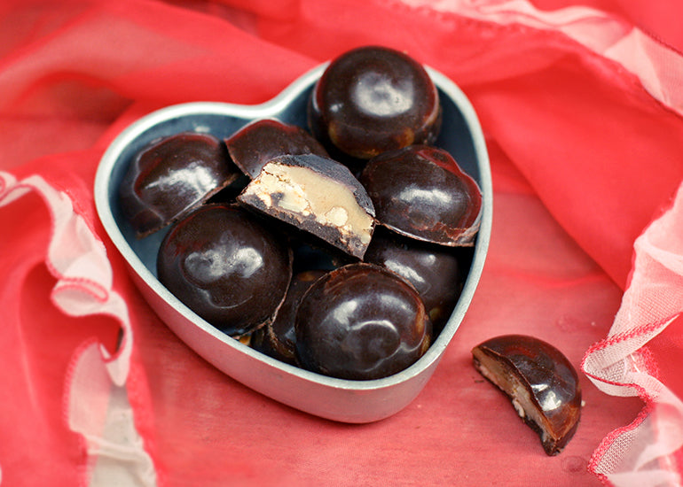 A heart-shaped box filled with salted caramel bonbons made with Navitas Organics Cacao Powder, Maca Powder and Cacao Butter