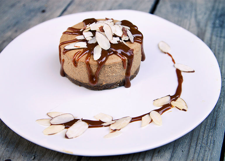 Raw vegan pumpkin chia mousse cake drizzled with caramel sauce and topped with slivered almonds