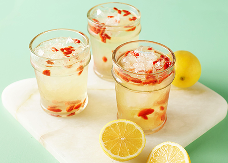 Three mason jars filled with goji lemonade made with Navitas Organics Goji Berries and fresh lemons.