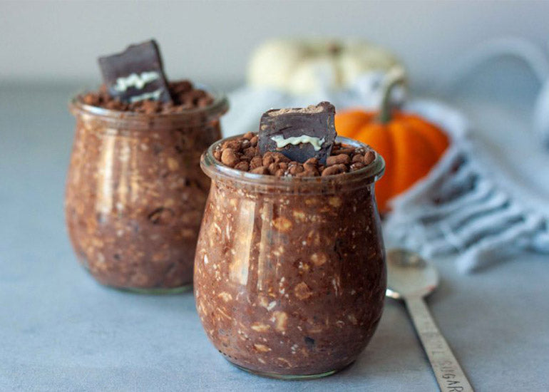 Two glass jars filled with chocolate chia overnight oats made with Navitas Organics Chia Seeds and Cacao Powder, themed for Halloween