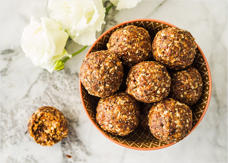 A bowl filled with truffles made with Navitas Organics Maca Powder, Chia Seeds, Goji Berries and a variety of fruit and nuts