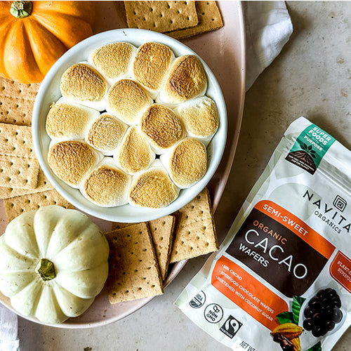 A dish filled with a pumpkin s'mores dip made with Navitas Organics Semi-sweet Cacao Wafers