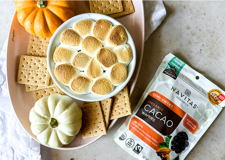 A dish filled with a pumpkin s'mores dip made with Navitas Organics Semi-sweet Cacao Wafers