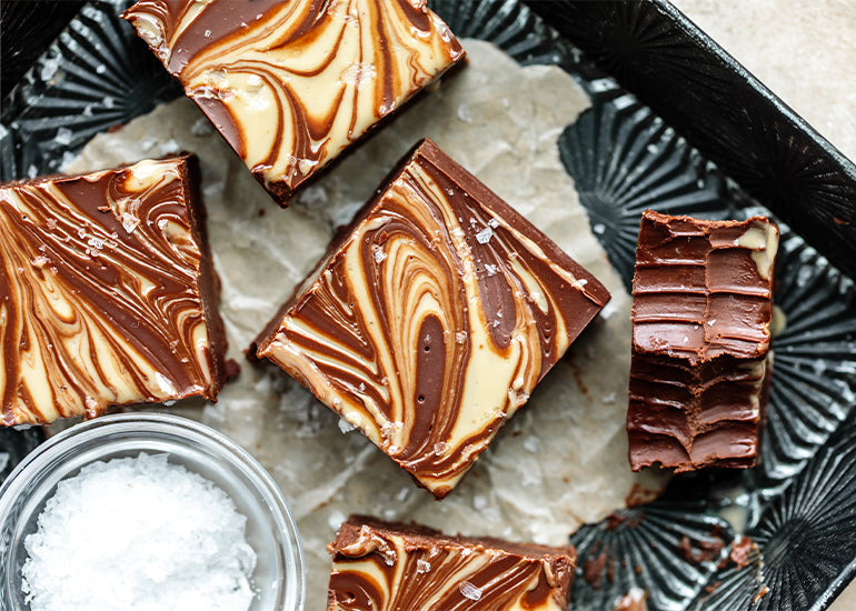 A pan filled with squares of chocolate tahini fudge made with Navitas Organics Semi-sweet Cacao Wafers and Superfood+ Adaptogen Blend