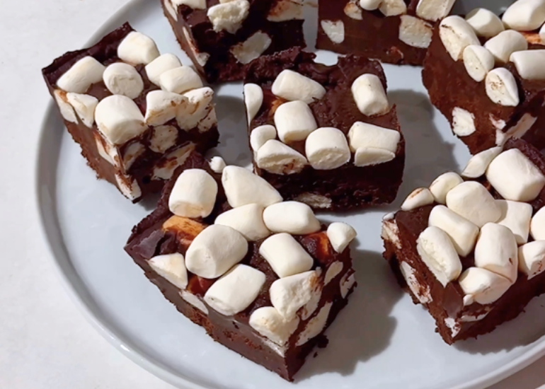 A plate of thick, rich chocolate fudge pieces made with Navitas Organics Cacao Wafers and Cacao Powder, topped with mini marshmallows.